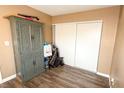 Bedroom with hardwood flooring, neutral walls, and a double sliding-door closet and cabinet at 2722 Sweet Basil Dr, Las Vegas, NV 89142
