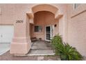 Inviting front porch with an arched entryway, potted plants, and a cozy bench, leading to the front door at 2809 Du Barry Manor Ln, Las Vegas, NV 89108