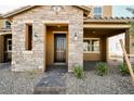 Welcoming entryway with stone accents, covered porch, and decorative lanterns, enhancing curb appeal at 3240 Avernus Ave, Henderson, NV 89044
