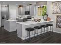 Modern kitchen with white countertops, stainless steel appliances, and a breakfast bar with seating at 3426 Oristano Ln, Henderson, NV 89044