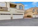 Two-story tan condo featuring garage access and minimal desert landscaping at 3936 Pepper Thorn Ave # 102, North Las Vegas, NV 89081