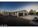 Three car attached garage and covered patio, a white brick home with black doors and black shutters at 3950 Oakridge Ave, Pahrump, NV 89048