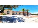 Inviting single-story home with xeriscaping, mature trees, and a wide driveway leading to a double-door entrance at 4119 Meadowglen Cir, Las Vegas, NV 89121