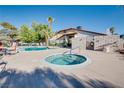 Community pool and hot tub with surrounding lounge area for relaxing and enjoying the outdoors at 5242 Dickens Dr, Las Vegas, NV 89119