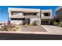 Contemporary home boasts clean lines, stone accents, desert landscaping, and an inviting entrance at 53 Falling Ridge Ln, Henderson, NV 89011