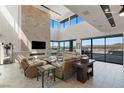 This impressive living room has high ceilings, multiple seating areas and beautiful views through the floor to ceiling glass at 53 Falling Ridge Ln, Henderson, NV 89011