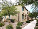 Home exterior with tan stucco, brown trim, desert landscaping and a sidewalk at 6168 Scarlet Leaf St, Las Vegas, NV 89148