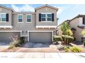 Charming townhome featuring a 2-car garage and a well-maintained front yard with lush landscaping at 6650 Drusilla St, North Las Vegas, NV 89084