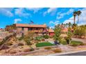 Southwestern style two-story home featuring landscaped grounds and a vibrant green lawn at 7470 Eldora Av, Las Vegas, NV 89117