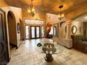 Grand foyer with high ceilings, custom ironwork, and chandelier, with an arched doorway, columns, and elegant tile flooring at 7625 Coley Ave, Las Vegas, NV 89117