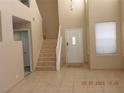 Bright foyer featuring tile flooring, a staircase, and high ceilings at 7840 Millhopper Ave, Las Vegas, NV 89128