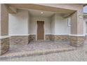 Inviting front porch with brick columns and textured stucco walls providing a warm and welcoming entrance at 790 Sunny Sagebrush St, Henderson, NV 89011