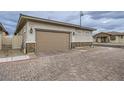 View of the home garage featuring a brick-accented facade and neutral tones in a well-maintained neighborhood at 790 Sunny Sagebrush St, Henderson, NV 89011