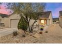 Inviting home exterior featuring desert landscaping and a cozy front porch seating area at 7934 Kiskadee St, North Las Vegas, NV 89084