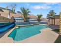 Backyard pool with water feature, blue tile accents, and lush landscaping, perfect for outdoor relaxation at 8029 Chablis Bay St, Las Vegas, NV 89131