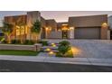 Stunning modern home featuring sleek design, a paved driveway, well-manicured lawn, and enhanced lighting at 819 Bolide St, Las Vegas, NV 89138