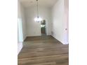 Bright living room featuring vaulted ceiling and wood laminate flooring, open to the kitchen at 8901 Kingsmill Dr, Las Vegas, NV 89134