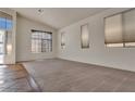 Bright living room featuring plush carpeting, large windows, and a vaulted ceiling at 8940 Emery Lake St, Las Vegas, NV 89123