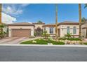 Tan stucco home with a tile roof, decorative wrought iron gate, and desert landscaping at 10408 Mezzanino Ct, Las Vegas, NV 89135
