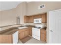 Functional kitchen featuring white appliances, wood cabinets, and neutral countertops at 10550 W Alexander Rd # 2233, Las Vegas, NV 89129