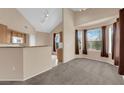 Cozy living room featuring neutral carpeting, plentiful windows and adjacent kitchen area at 10550 W Alexander Rd # 2233, Las Vegas, NV 89129