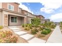 Beautifully landscaped front exterior of a modern home with walkway and manicured garden beds at 10777 Briset Ct, Las Vegas, NV 89166