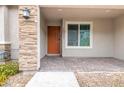 Inviting front porch with stone accents, brick pavers and a dark wood front door at 10777 Briset Ct, Las Vegas, NV 89166