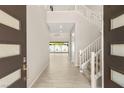 Welcoming foyer showcasing a grand staircase and a view of the backyard oasis through the living area at 12048 Portamento Ct, Las Vegas, NV 89138