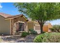 View of a charming single-story home featuring stone accents, desert landscaping, and a well-maintained front yard at 1561 Campfire Ln, Mesquite, NV 89034