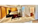 Open kitchen featuring granite countertops, stainless steel appliances, and wooden cabinetry at 2524 Charleville Ave # 102, Las Vegas, NV 89106