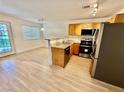 Bright kitchen with stainless steel appliances, stone counters, breakfast bar and wood-look flooring at 2524 Charleville Ave # 102, Las Vegas, NV 89106