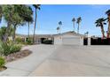 Charming one-story home with white exterior, attached garage, and circular driveway lined with mature trees and lush landscaping at 3175 S Torrey Pines Dr, Las Vegas, NV 89146