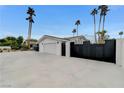Side view of home showing a large garage with a big driveway, a well-maintained white exterior, and a black metal fence at 3175 S Torrey Pines Dr, Las Vegas, NV 89146