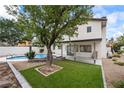 Landscaped backyard offering a pool, artificial grass, mature trees, and privacy at 389 Umbria Way, Henderson, NV 89014