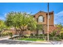 Inviting home featuring an attached three-car garage, stucco and stone accents, and lush landscaping at 409 Lake Windemere St, Las Vegas, NV 89138