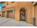 A close up of an arched entryway to the home, showing the attached garage and stone accents at 409 Lake Windemere St, Las Vegas, NV 89138