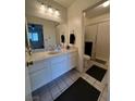 This bathroom features a large vanity and mirror, and a shower behind a sliding glass door at 4662 Kelly Barry Way, Las Vegas, NV 89121