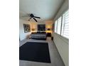 This bedroom features a ceiling fan, a patterned bedspread, and a window with shutter blinds at 4662 Kelly Barry Way, Las Vegas, NV 89121