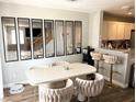 Dining area features a white table with six upholstered chairs and modern mirror decor at 5024 Starfinder Ave, Las Vegas, NV 89108