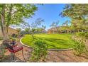 A spacious back yard with mature trees and green grass is ready for entertaining at 5701 Mary Lou St, Pahrump, NV 89061