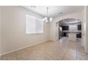 Bright dining room with tile floors leading to an open kitchen with stainless appliances at 6412 Dimatteo St, Las Vegas, NV 89148