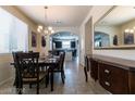 Formal dining room with tile flooring, chandelier, wainscoting and room for hosting dinner parties at 6412 Dimatteo St, Las Vegas, NV 89148
