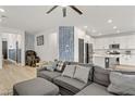 Comfortable living room with a large gray sofa, modern decor, and open to the kitchen area at 7122 Red Gulch St, North Las Vegas, NV 89084