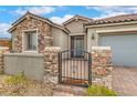 Charming home entrance with a stone facade, iron gate, and warm 'Home Sweet Home' welcome mat at 8257 Skye Peak St, Las Vegas, NV 89166