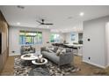 Bright, open-concept living room with a ceiling fan and large windows overlooking the backyard at 8647 Tortoise Canyon Ct, Las Vegas, NV 89148