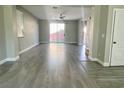 Bright, open-concept living room with gray wood floors, and sliding glass doors that fill the room with light at 8990 Partridge Hill St, Las Vegas, NV 89148