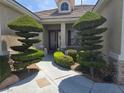 Inviting front entrance with meticulously manicured topiaries and a well-maintained walkway at 1100 Cypress Ridge Ln, Las Vegas, NV 89144