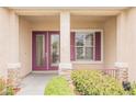 Inviting entryway with a decorative glass door, sidelight, and complementary maroon shutters at 1100 Cypress Ridge Ln, Las Vegas, NV 89144