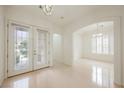 Spacious foyer with a glass double door entry and an arched doorway leading to a dining area at 1100 Cypress Ridge Ln, Las Vegas, NV 89144