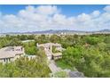 Expansive estate with lush landscaping, circular driveway, and views of the mountains in the distance at 12056 Royal Dolnoch Ct, Las Vegas, NV 89141